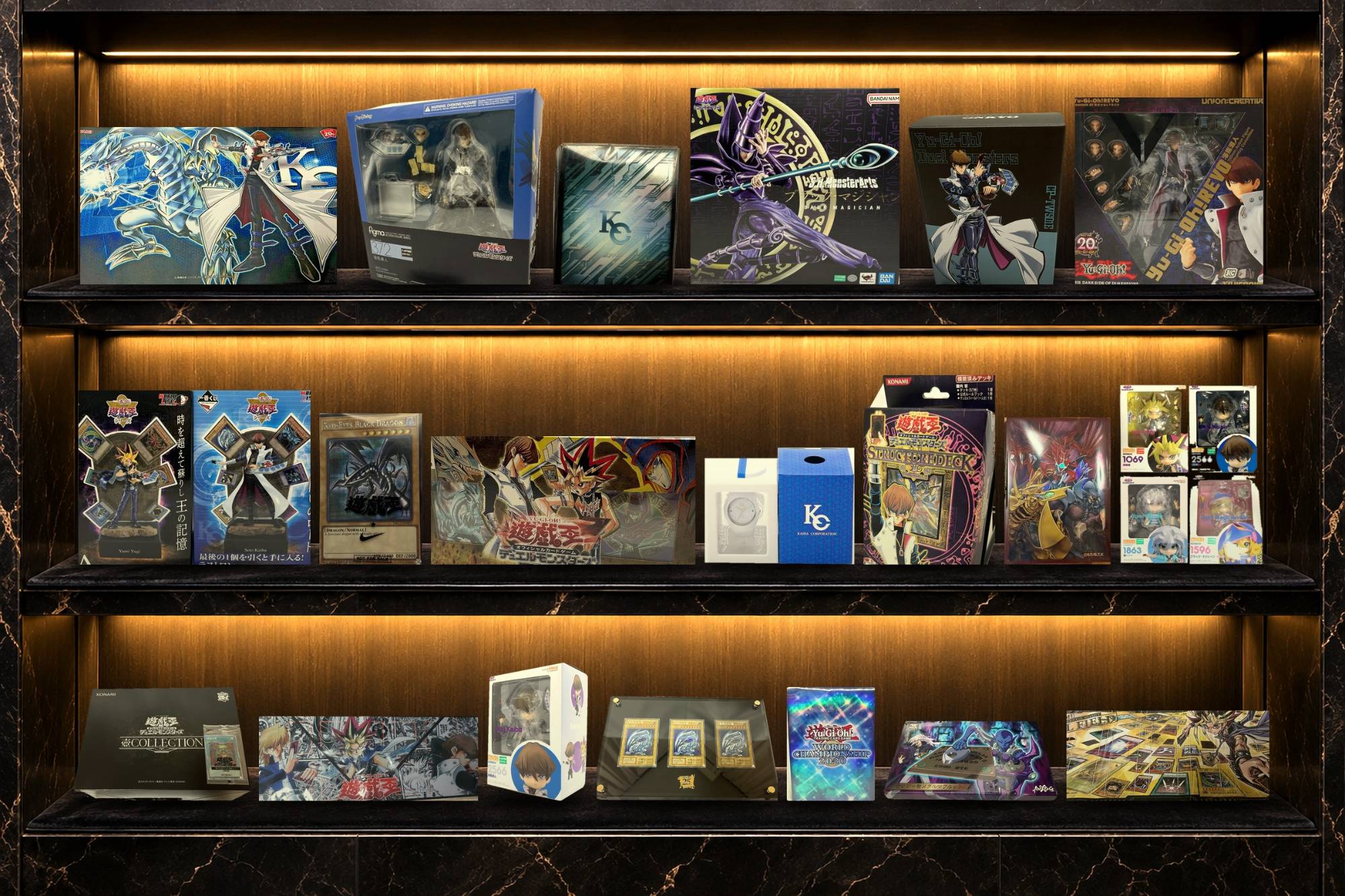 A lit display shelf of Yu-Gi-Oh! figures, collector boxes, playmats and official goods from Japan